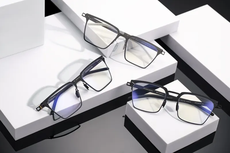 Metal optical frames arranged on stepped white and black blocks.