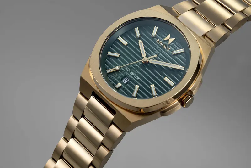 Gold wristwatch with a dark blue textured dial, gold hour markers and a date window at six o'clock.