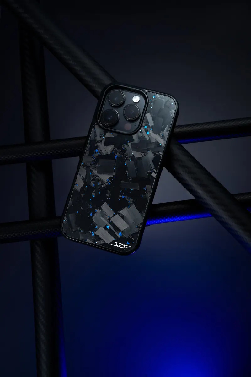 Phone in a camouflage forged-carbon case between black carbon tubes with a blue glow.